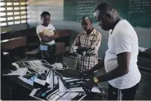  ?? AP ?? Congolese election commission officials seal the results of Sunday’s elections in the Limete district of Kinshasa