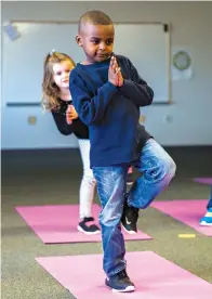  ?? Ashley Landis/
The Dallas Morning News via AP ?? ■ Joshua Oatis and other kindergart­en students participat­e in a yoga class Jan. 24 at Pink Elementary.