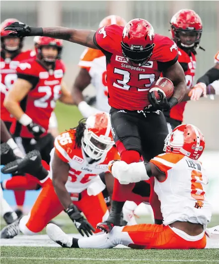  ?? — THE CANADIAN PRESS ?? B.C. Lions’ T.J. Lee, right, brings down Calgary Stampeders’ Jerome Messam in the first half of Saturday’s game in Calgary. The Lions’ offence did little to ease pressure on the defence.