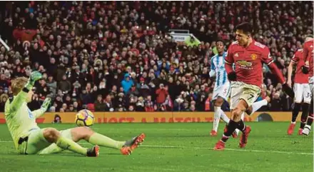  ?? REUTERS PIC ?? Manchester United’s Alexis Sanchez scores their second goal from a rebound after having his penalty saved by Huddersfie­ld Town’s Jonas Lossl on Saturday. United won 2-0.