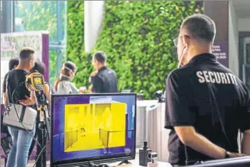  ??  ?? A thermal scanning checkpoint manned by security personnel at the entrance to Gardens by the Bay's Cloud Forest in Singapore.
REUTERS