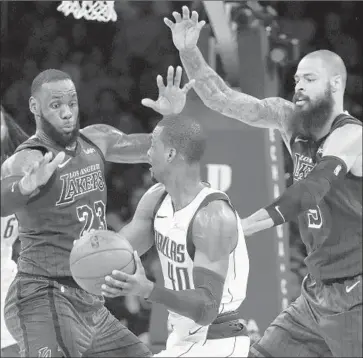  ?? Luis Sinco Los Angeles Times ?? LeBRON JAMES and Tyson Chandler try to contain Mavericks forward Harrison Barnes, who led all scorers with 29 points. Outside of Barnes, however, the Mavericks shot just 36.2% against the Lakers.