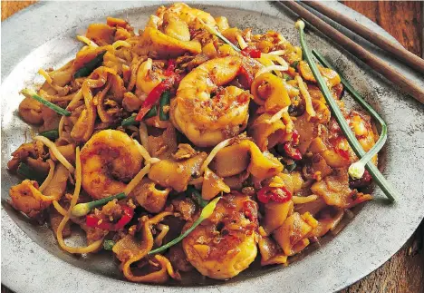  ?? PENNY DE LOS SANTOS ?? Penang’s famous char kway teow, a Malaysian street food favourite, relies on its broad cross-cultural medley of spices. Christina Arokiasamy’s latest cookbook pays homage to the flavours she remembers from her childhood experience­s on the Malaysian...