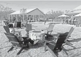  ?? ?? Customers enjoy the outdoor seating around fire pits at Tall Oaks Farm + Brewery in Farmingdal­e. The covered and heated events pavilion can be seen in the background, as well as more outdoor seating areas.
