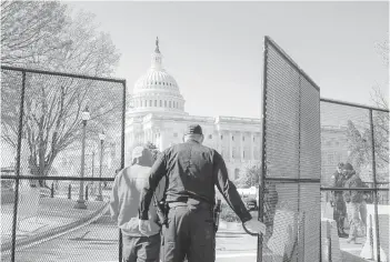  ?? AMR ALFIKY/THE NEW YORK TIMES ?? A Capitol Police officer opens a gate outside the Capitol building Saturday in Washington, near where a car rammed into a security barrier Friday, killing an 18-year veteran of the force. The driver was shot and killed.