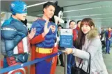  ?? SONG WEIWEI / XINHUA ?? Workers dressed as cartoon characters wave goodbye to passengers boarding the maiden flight of the Fuzhou-New York route on Wednesday. This is the first direct flight that links Southeast China’s Fujian province with the United States.
