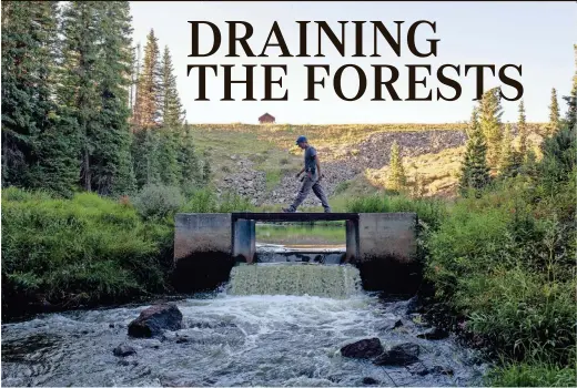  ?? MARK HENLE/THE REPUBLIC ?? Water Commission­er John Walker walks across the flume to get water flow measuremen­ts at Park Reservoir in the Grand Mesa National Forest in Colorado.