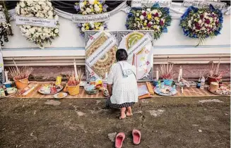  ?? Andre Malerba/New York Times ?? A mourner pays her respects Saturday at Wat Rat Samakee temple in Uthai Sawan, Thailand. A fired police officer killed 24 children at a day care and 12 others Thursday.