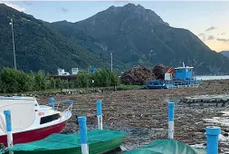  ??  ?? Costa Volpino Il battello spazzino in azione sui detriti nel lago d’Iseo