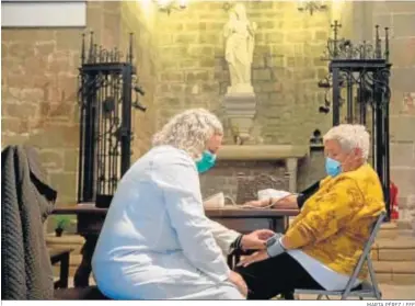  ?? MARTA PÉREZ / EFE ?? Una mujer es atendida por una sanitaria en la parroquia de Santa Anna de Barcelona.