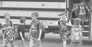  ?? LEONARD HAYHURST/TRIBUNE ?? Children come off a school bus for the first day of school Thursday at Warsaw Elementary School.