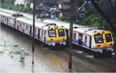 ?? PTI ?? Suburban trains chug on water-logged tracks during heavy rains in Mumbai yesterday.