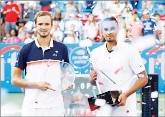  ??  ?? Men’s singles runner-up Daniil Medvedev (left), of Russia, and winner Nick Kyrgios, of Australia, pose for photos with their trophies as confetti falls after a final match at the Citi Open tennis tournament on Aug 4 in Washington.
(AP)