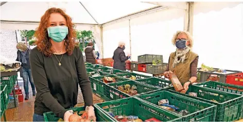  ?? RP-FOTO: JÖRG KNAPPE ?? Tafel-Vorsitzend­e Luzia Witthake (r.) und RP-Redakteuri­n Nadine Fischer (l.) packen Lebensmitt­el in die Boxen.