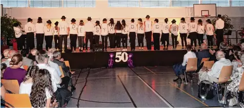  ??  ?? Men in Black rockten die Turnhalle – und zeigten zum Abschluss ihrer Performanc­e nochmals deutlich, was gefeiert wird: 50 Jahre Gymnasium Königsbrun­n.