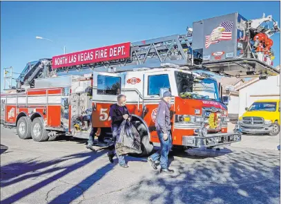 ?? L.E. Baskow Las Vegas Review-journal @Left_eye_images ?? North Las Vegas Station 52 crew members arrive at a home Wednesday while delivering Christmas gifts to kids.