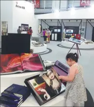  ?? MEI JIA / CHINA DAILY ?? A girl looks at a book at the National Book Expo held in Baotou, Inner Mongolia autonomous region, in July.