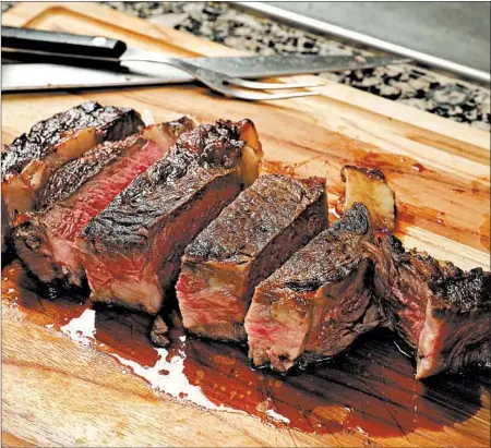  ?? CHRIS WALKER/CHICAGO TRIBUNE PHOTOS; SHANNON KINSELLA/FOOD STYLING ?? When you cut into the steak, you see a thin layer of browned meat around the edges and an interior that remains mostly rosy pink from top to bottom.