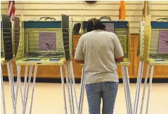  ?? JOHN AUSTRIA/JOURNAL ?? Carolyn Yazzie fills in her ballot at the Shiprock Chapter House in 2015.