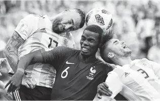  ?? Franck Fife / AFP / Getty Images ?? France midfielder Paul Pogba (center) heads the ball with Argentina defenders Nicolas Otamendi (left) and Nicolas Tagliafico during Saturday’s round of 16 match. France eliminated Argentina.