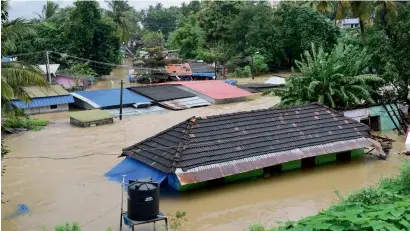  ?? PTI ?? A view of houses submerged in water following a flash flood, triggered by heavy rains in Palakkad on Thursday. —