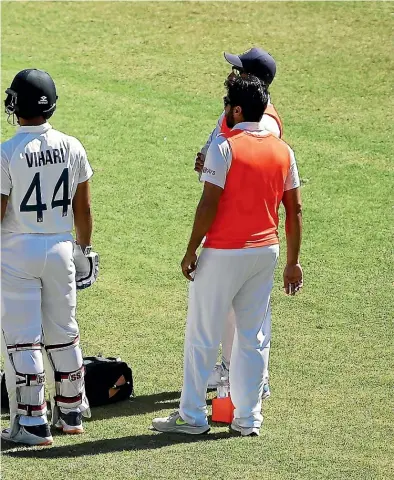  ??  ?? Ravichandr­an Ashwin receives attention after being struck by a short ball during day five of the third test match between India and Australia in Sydney.