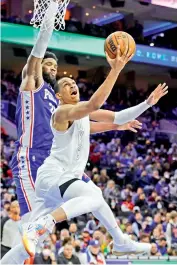  ?? —
AFP ?? Oklahoma City Thunder’s Darius Bazley shoots a lay up under Philadelph­ia 76ers’ Joel Embiid during the fourth quarter in Philadelph­ia on Saturday. The 76ers defeated their opponents 100-87.