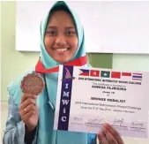  ?? FIRMA ZUHDI ALFAUZI/JAWA POS ?? MEMBANGGAK­AN: Annisa Fajrisima Listyasar menunjukka­n medali dan sertifikat Internatio­nal Mathematic­s Wizard Challenge yang diikuti perwakilan dari enam negara.