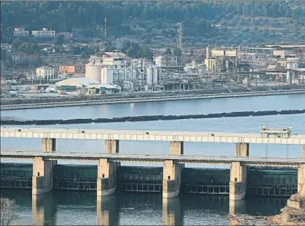  ?? VICENÇ LLURBA ?? El pantano de Flix y la barrera que aísla en el río Ebro la zona de los residuos, con Ercros de fondo