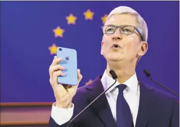  ?? Associated Press ?? Apple CEO Tim Cook holds up an iPhone as he speaks during a data privacy conference at the European Parliament in Brussels on Wednesday.