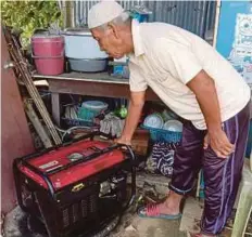  ??  ?? SEORANG penduduk melihat generator yang menjadi sumber bekalan elektrik kepada penduduk Kampung Tersusun.