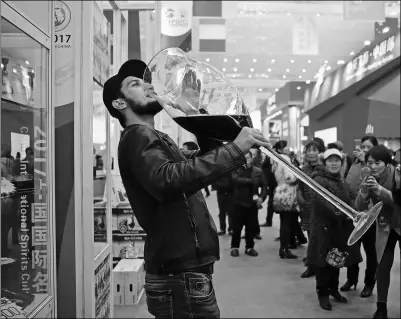  ?? ZENG LANG / FOR CHINA DAILY ?? An exhibitor of a wine company drinks from a huge glass to promote sales among visitors at the China Internatio­nal Wine, Beer and Spirits Culture Festival 2017 in Yibin, Sichuan province, in Southwest China. In addition to 100 Chinese clear spirits...