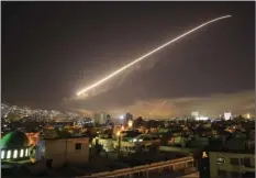  ?? AP PHOTO/HASSAN AMMAR ?? The Damascus sky lights up with missile fire as the U.S. launches an attack on Syria targeting different parts of the capital Friday.