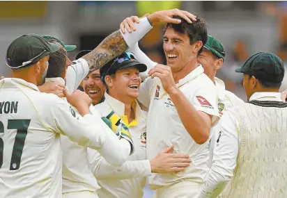  ??  ?? Steve Smith and Pat Cummins (centre) celebrate with their teammates after Australia secured victory in the first Ashes Test match.