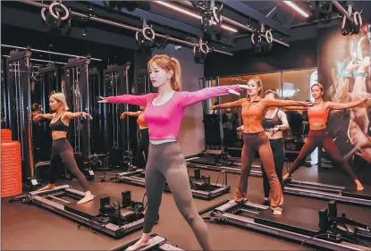  ?? PHOTOS PROVIDED TO CHINA DAILY ?? Members take a Pilates class at a Pure yoga studio at Jing’an Kerry Center in Shanghai in October.