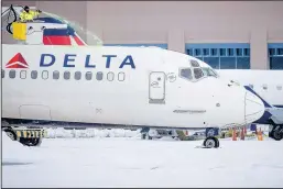  ??  ?? Workers de-ice a Delta Airlines plane at the Albuquerqu­e Internatio­nal Sunport.