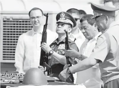  ??  ?? DUTERTE (dua kanan) dan Ano (dua kiri) memeriksa raifal Kalashniko­v sambil diperhatik­an Shoigu (kanan) semasa upacara penyerahan di Pelabuhan Manila semalam. — Gambar AFP