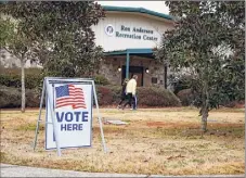  ?? Todd Kirkland / Associated Press ?? Voters return to their vehicles after early voting in the Senate runoff election in Powder Springs, Georgia. Civil rights groups and the U.S. Postal Service reached an agreement on speedier ballot handling procedures ahead of the run-off election in January.