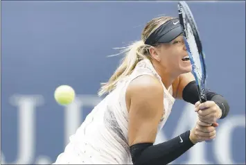  ?? ADAM HUNGER – THE ASSOCIATED PRESS ?? Maria Sharapova returns a shot from Timea Babos during their second-round match Wednesday at the U.S. Open. Sharapova won to advance to the third round in her first major tournament since coming off a suspension.