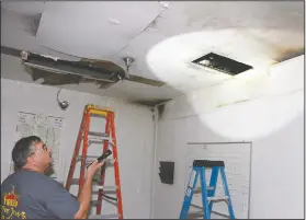  ?? Terrance Armstard/News-Times ?? Investigat­e: Union County Chief Deputy Charlie Phillips inspects the ceiling of the kitchen at the Union County Criminal Justice Facility after a fire damaged several areas inside the building. Wednesday.