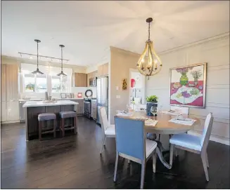  ??  ?? The teardrop-shaped chandelier adds some eclectic flair to an otherwise neutral open living area in the two-bedroom, 1001-sq.-ft display suite.