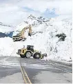  ??  ?? Road crews work to clear avalanche debris Friday from the Icefields Parkway between Banff and Saskatchew­an River Crossing.