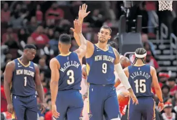  ?? ?? Willy Hernangóme­z choca la mano con CJ McCollum en un partido de pretempora­da de los Pelicans.