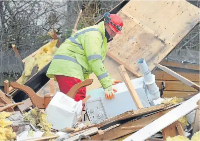  ?? Picture: Central Scotland News Agency. ?? Officials recover the boiler from the remains of Robin and Marion Cunningham’s home in Callander, Perthshire, which was demolished by a gas explosion in March 2013.