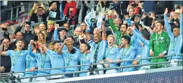  ??  ?? Vincent Kompany lifts the trophy as Manchester City players celebrate their victory after the English League Cup final at Wembley stadium.