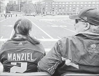  ?? HAMILTON SPECTATOR FILE PHOTO ?? A Hamilton Tiger-Cats fan wears a Manziel jersey during the first day of the team’s training camp in May. Manziel is shown below on the very same day.