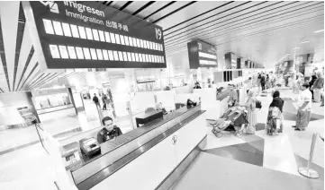  ??  ?? Customs officers man immigratio­n counters at the Kuala Lumpur Internatio­nal Airport. Prestarian­g’s SKIN project is not expected to be discontinu­ed as even the new government comes into place as the system is still viewed as a necessity to the country,...