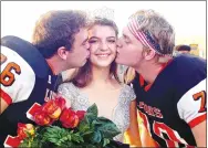  ?? Westside Eagle Observer/RANDY MOLL ?? After being crowned Gravette homecoming queen at Friday night ceremonies at Gravette High School, Hannah Westrick receives a ceremonial kiss from her escorts, seniors Beau Hamilton and Aidan Patton.