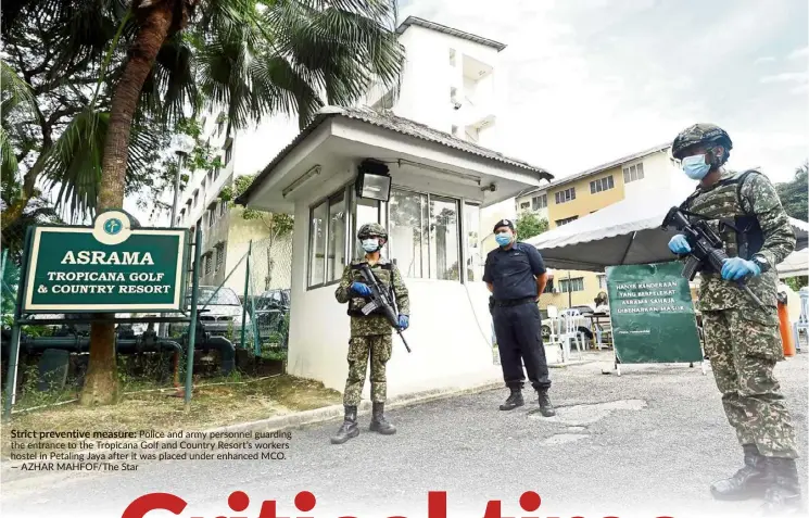  ?? — AZHAR MAHFOF/ The Star ?? Strict preventive measure: Police and army personnel guarding the entrance to the Tropicana Golf and Country Resort’s workers hostel in Petaling Jaya after it was placed under enhanced MCO.