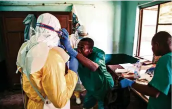  ??  ?? Le personnel de l’hôpital de Bikoro, en RDC, enfile des vêtements de protection avant d’aller soigner les malades.